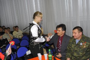 Студентка Екатерина Сопина вручает цветы и подарок бывшему воину-интернационалисту Александру Сергеевичу Романову.